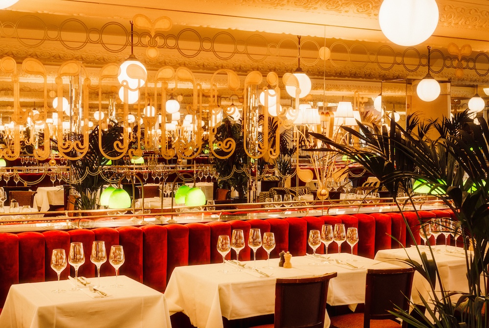 Elegant interior of Brasserie Thoumieux in Paris with red velvet seating and Belle Époque decor.
